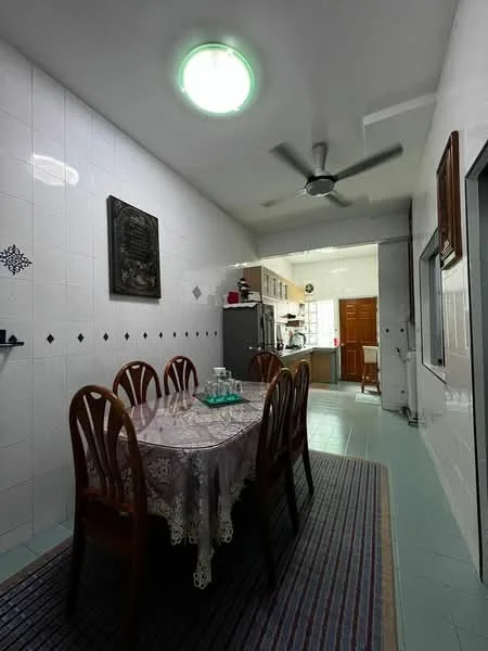 Dining features: rectangular dining table with lace tablecloth, 8 wooden dining chairs, white tiled walls, green ceiling light fixture, ceiling fan, light blue tiled flooring, area rug with geometric pattern, wooden cabinetry in background, kitchen area visible in background; style: traditional.
