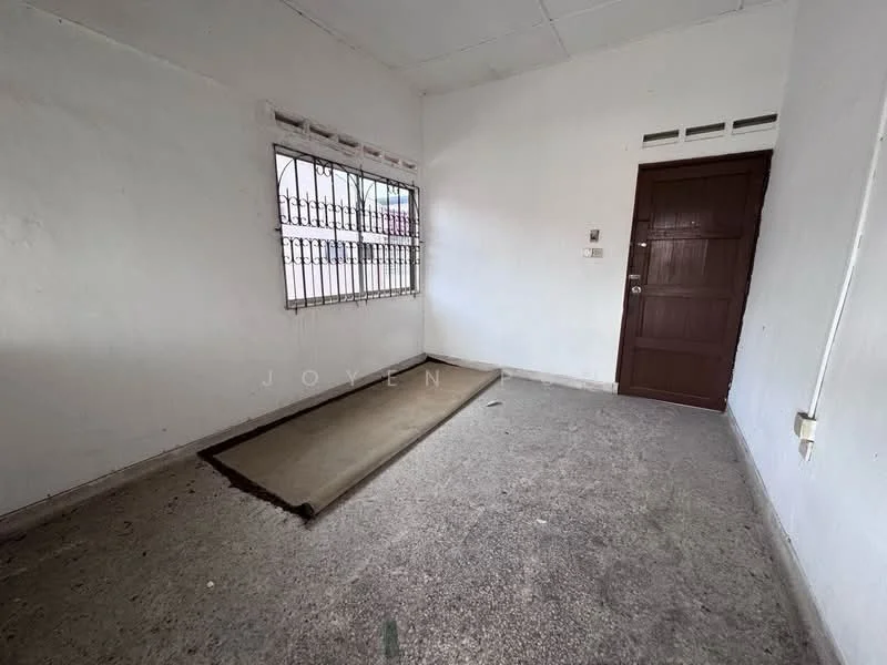 Room features: white painted walls, concrete flooring, window with security bars, single wooden door, corner layout, no visible furniture, minimal natural light, plain ceiling; style: minimalist.
