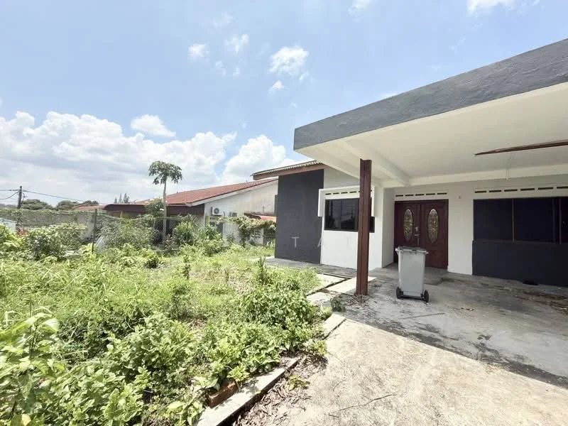 Exterior type: detached bungalow; features: grey painted facade, flat roof, concrete flooring, large windows, double-door entrance, surrounding overgrown garden, exposed concrete walls, outdoor space, manicured lawn area, visible utility connections; style: modern.