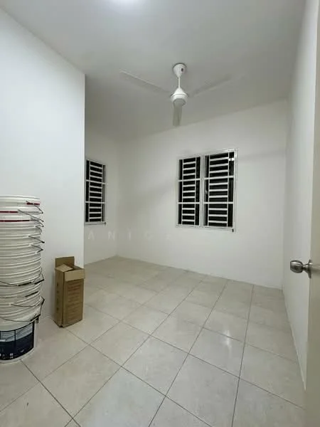 Room features: white painted walls, tile flooring, ceiling fan, two windows with grilles, empty space, stack of paint buckets, cardboard box.