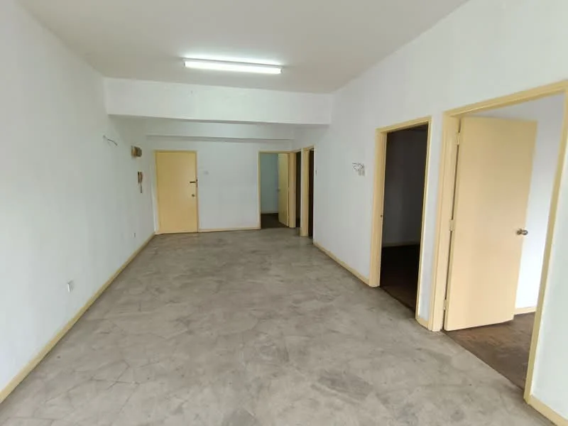 Room features: white painted walls, grey tiled flooring, ceiling with fluorescent lighting, multiple doorways, open layout, no visible furniture, neutral color scheme, plain ceiling; style: minimalist.