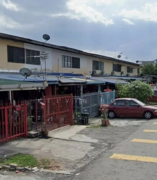 Exterior type: linked terrace house; features: red painted facade, single-storey, metal roof, front yard with gate, satellite dishes on roof, parking space in front, manicured plants in pots, concrete walkway, street view with yellow road markings; style: traditional.