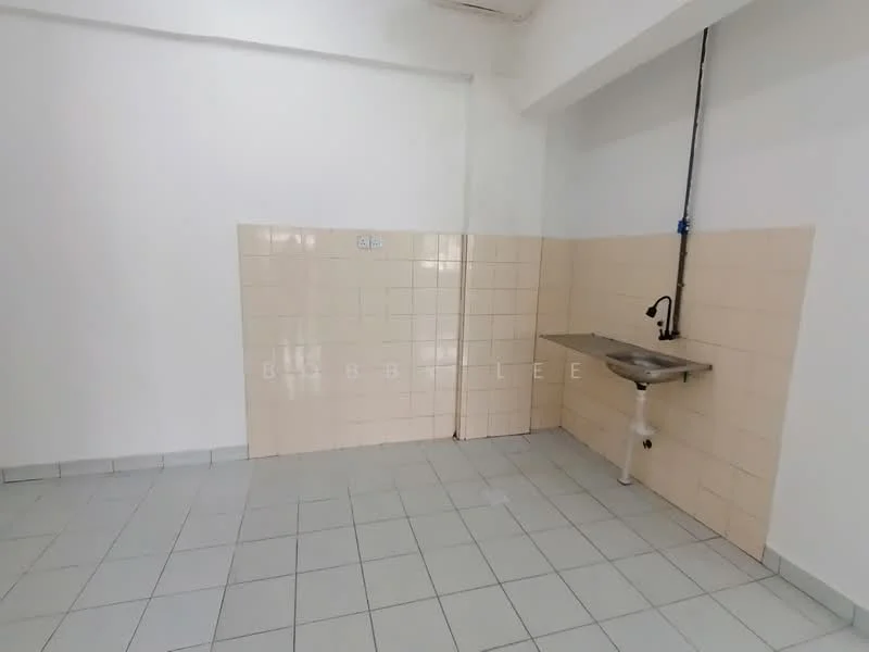 Room features: light beige tiled walls, white tiled backsplash, grey floor tiles, stainless-steel sink, chrome faucet, wall-mounted pipe, empty wall space, no visible cabinetry.