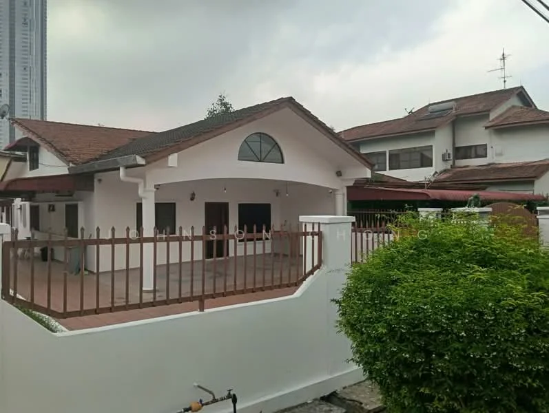 Exterior type: detached bungalow; features: white painted facade, pitched tile roof, arched window, fenced front yard, paved driveway, landscaped garden with shrubs, single-storey, surrounded by greenery; style: traditional.