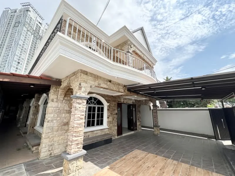 Exterior type: detached bungalow; features: stone cladding facade, white painted trim, recessed balconies, gabled roof, covered car porch, paved driveway, arched windows, manicured landscaping, surrounded by greenery, two-storey structure, modern urban context; style: modern.