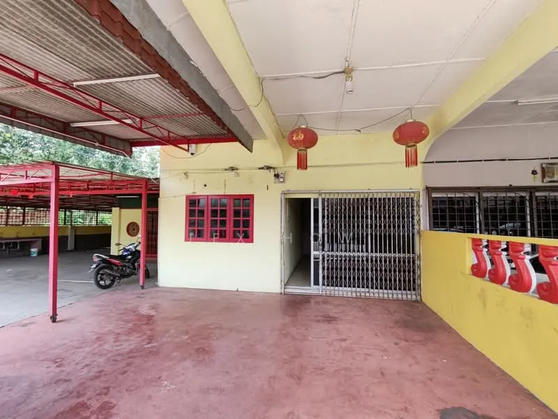 Exterior features: yellow painted walls, red metal roof, concrete flooring, security grille door, red window frames, hanging red lanterns, open parking area, covered carport, exposed ceiling, surrounding greenery; style: traditional.