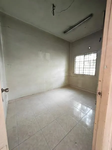 Room features: plain white walls, tile flooring, single window with metal grille, fluorescent ceiling light, no visible furniture, empty room, corner room, neutral color scheme; style: minimalist.