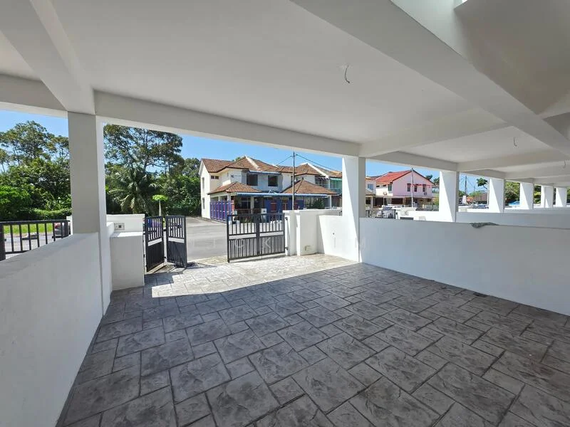 Exterior type: parking deck; features: open-air parking lot, paved flooring with stone pattern, white painted walls, gated entry, surrounded by greenery, adjacent to residential buildings; style: modern.