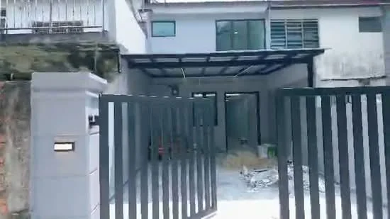 Exterior type: semi-detached house; features: grey painted facade, metal gate, car porch with awning, concrete driveway, large windows, sliding glass door, manicured lawn, exposed brick wall, covered entrance, single-storey, surrounded by greenery; style: modern.