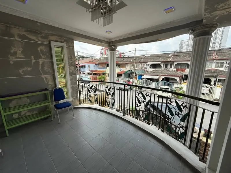 Balcony features: curved balcony design, grey tiled flooring, metal railing with decorative pattern, chandelier light fixture, two columns supporting the roof, green shelving unit, single blue chair, view of street and houses; style: modern; view: street.