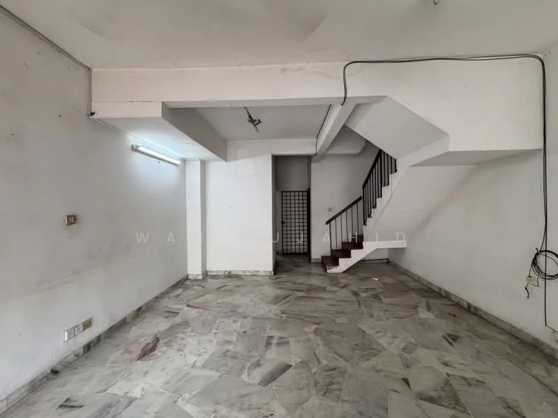 Room features: marble flooring, white painted walls, staircase with wooden railing, ceiling with exposed beams, wall-mounted electrical outlets, light fixture on ceiling, open layout, natural light from windows; style: minimalist.