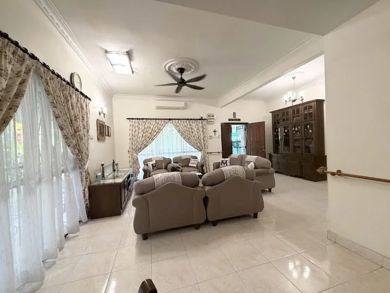 Living features: cream painted walls, white ceiling with crown moulding, 5-blade ceiling fan with light, large windows with sheer curtains, tiled flooring, 2 beige fabric sofas, wooden coffee table, decorative wall clock, built-in wooden cabinet, dining area visible in background, wall-mounted air conditioning unit; style: traditional.