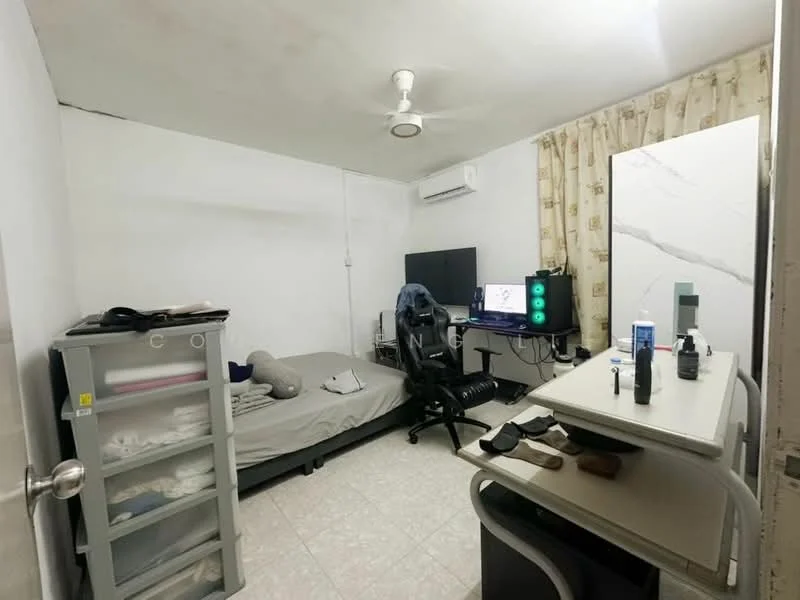 Bedroom features: single bed with grey bedding, black office chair, computer desk with monitor, white shelving unit, wall-mounted air conditioning unit, ceiling fan, curtains with floral pattern, light-colored tiled flooring, decorative mirror, wall-mounted TV; style: minimalist.