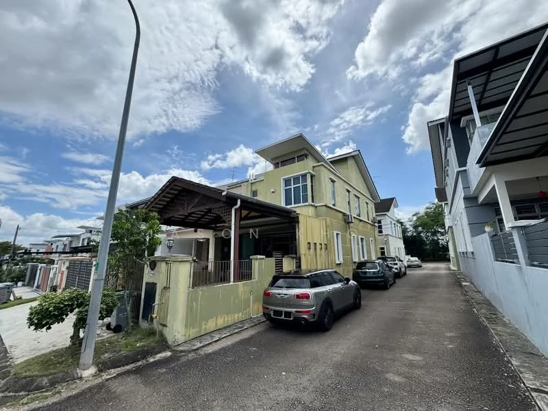 Exterior type: detached bungalow; features: yellow painted facade, two-storey building, gabled roof, covered porch, driveway with parking space, surrounded by greenery, adjacent to other residential buildings, windows with white frames, visible cars parked, street lamp, cloudy sky; style: modern.