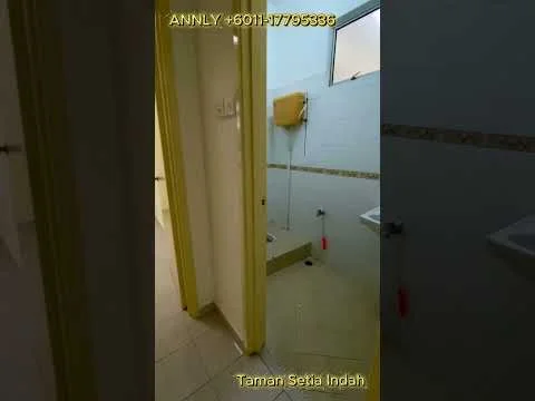 Bathroom features: white tiled walls, cream tiled flooring, shower area with handheld shower, toilet, sink with chrome faucet, mirror above sink, window for natural light, yellow door frame.