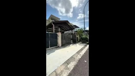 Exterior type: semi-detached house; features: covered car porch with awning, metal gate, fence with vertical slats, manicured lawn, paved driveway, single-storey structure, gabled roof, front porch area, surrounded by greenery, clear blue sky; style: modern.