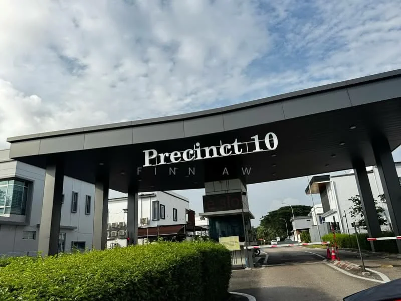 Exterior type: gated community; features: modern entrance gate, signage with 'Precinct 10', landscaped hedges, paved driveway, surrounding greenery, security barriers, parking area, two-storey buildings in background; style: modern.