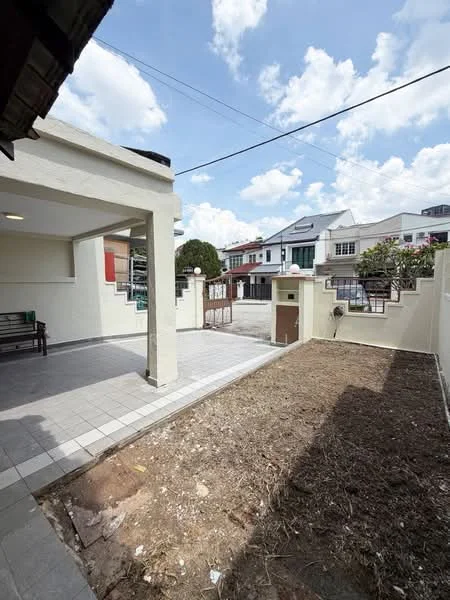 Exterior type: linked terrace house; features: paved walkway, manicured lawn area, fenced perimeter, outdoor seating area, single-storey, surrounded by residential buildings, clear blue sky; style: modern.