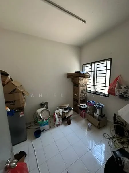 Room features: white painted walls, white tile flooring, single window with metal grille, cardboard boxes, various household items, small appliances, unorganized storage, light fixture on ceiling.