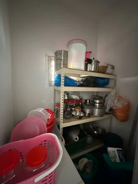 Room features: metal shelving unit, various pots and pans, plastic containers, basket with lids, blue plastic bags, storage bins, light-colored walls, window with sheer covering.