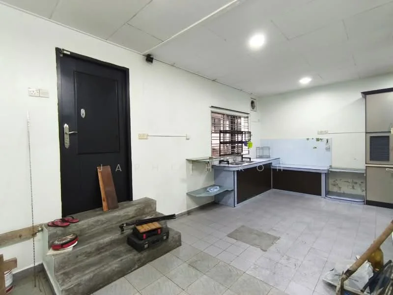 Room features: grey tiled flooring, white painted walls, black door, window with metal grille, kitchen countertop, open shelving, staircase with concrete steps, exposed electrical outlets, ceiling lights; style: modern.