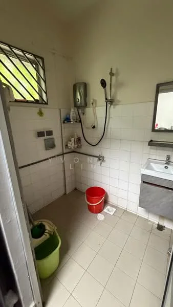 Bathroom features: white tiled walls, light grey tiled flooring, shower with handheld showerhead, wall-mounted water heater, single-sink vanity with mirror, chrome basin mixer, toilet, red bucket, green laundry basket.