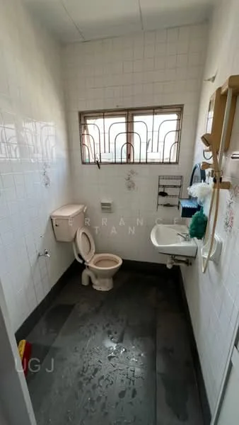 Bathroom features: white tiled walls, black ceramic tile flooring, one-piece toilet, chrome basin mixer faucet, small wall-mounted mirror, white sink, window with metal grille, towel rack, floral wall decoration.