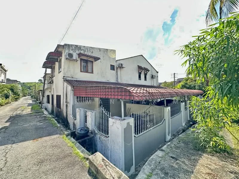Exterior type: detached bungalow; features: red tiled roof, white painted facade, exposed brick wall, metal gate, fenced perimeter, two-storey structure, air conditioning units visible, paved walkway, surrounded by greenery, adjacent to quiet residential street; style: traditional.
