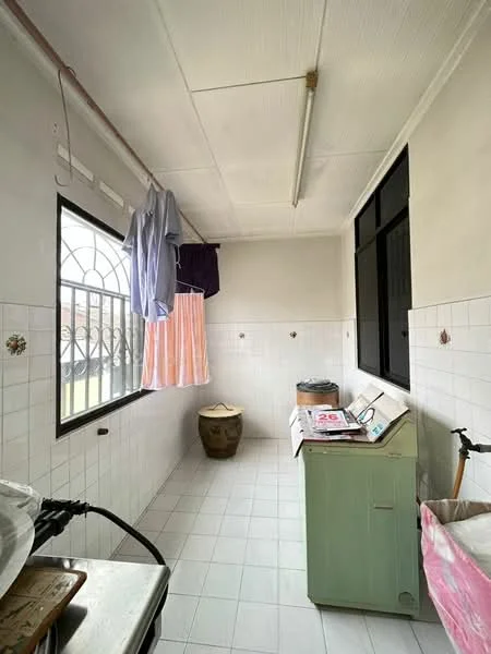 Laundry features: white tiled flooring, white painted walls, window with black metal grille, green laundry sink, washing machine, clothes drying rack, hanging clothes, ceramic pot, countertop with magazines, light fixture on ceiling.