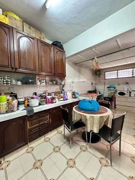 Kitchen features: brown wooden cabinetry, white countertop, stainless-steel sink, chrome faucet, round dining table, black dining chairs, ceramic tile flooring, wall-mounted fan, multiple kitchen appliances, various kitchen utensils and containers, window with metal grille, overhead lighting; style: traditional.