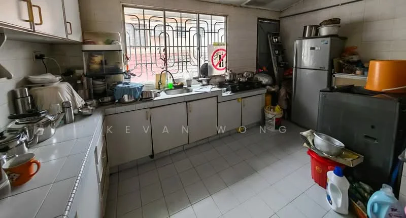 Kitchen features: white cabinetry, stainless-steel sink, chrome pull-down faucet, ceramic tile flooring, built-in gas stove, freestanding fridge, microwave, multiple pots and pans, countertop with clutter, window with metal grille, wall-mounted shelves, various kitchen appliances, plastic storage containers, cleaning supplies, dish rack.