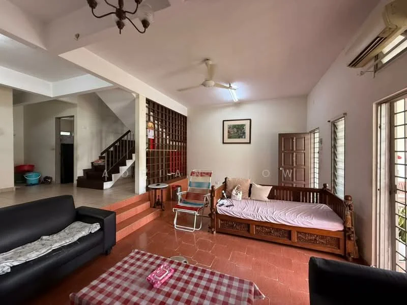 Living features: 2-seater black leather sofa, 3-seater wooden sofa with pink cushion, coffee table with checkered tablecloth, ceiling fan, wall-mounted air conditioning unit, laminate flooring, white painted walls, large windows with metal grilles, decorative wall art, wooden staircase in background; style: modern. Room features: open layout, staircase leading to upper floor, wooden partition wall, tile flooring, door leading outside.