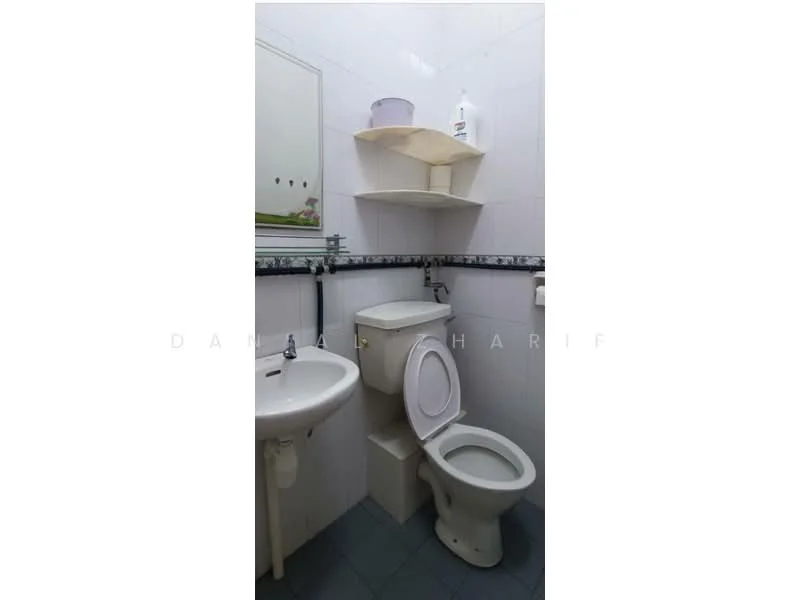 Bathroom features: white tiled walls, grey tiled flooring, single-sink vanity, white ceramic sink, chrome basin mixer faucet, toilet with white ceramic finish, built-in shelf above sink, mirror above sink, soap dispenser on shelf.