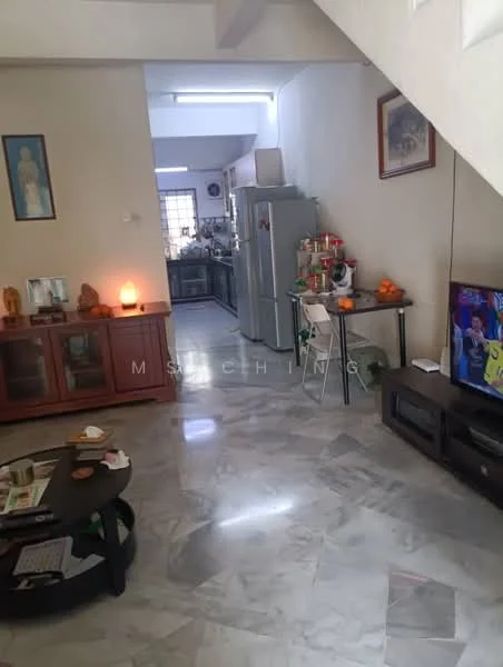 Living features: marble flooring, white painted walls, ceiling lights, wooden coffee table, TV console, wall-mounted TV, decorative wall art, cabinets with glass doors, refrigerator, kitchen visible in background, orange fruits on table, area rug.