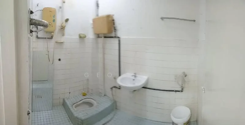 Bathroom features: white tiled walls, blue tiled flooring, toilet, squat toilet, sink, shower head, water heater, exposed plumbing, wall-mounted faucet.
