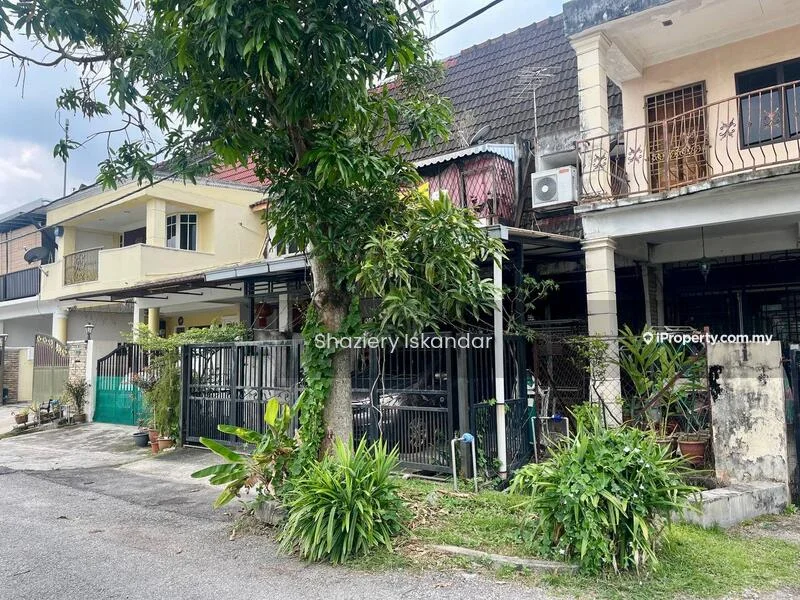 Exterior type: linked terrace house; features: two-storey building, metal gate, fenced front yard, manicured garden with shrubs, paved walkway, air conditioning unit visible, balcony on upper floor, front porch area, surrounded by greenery, street view; style: traditional.
