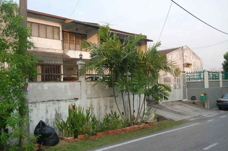 Exterior type: semi-detached house; features: white painted facade, two-storey structure, manicured lawn, palm trees, flower beds, fenced yard, driveway with slope, gate at entrance, street view, adjacent to road; style: traditional.