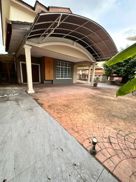 Exterior type: detached bungalow; features: arched roof with metal framing, paved driveway with stamped concrete, front porch with columns, large window with grid pattern, manicured garden area, exposed brick wall, outdoor lighting, surrounding greenery; style: modern.