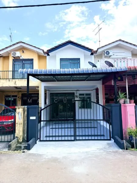Exterior type: linked terrace house; features: white painted facade, black metal gate, covered porch area, two-storey structure, visible windows with grilles, satellite dish on roof, air conditioning unit on wall, manicured front yard, paved driveway, adjacent houses visible; style: modern.