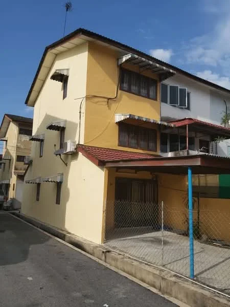 Exterior type: semi-detached house; features: yellow painted facade, flat roof, two-storey structure, balconies with awnings, multiple windows, exterior air conditioning units, fenced yard, paved driveway, surrounded by other residential buildings; style: traditional.