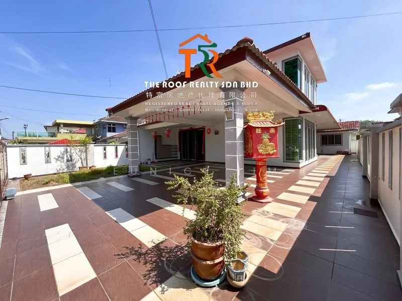 Exterior type: detached bungalow; features: flat roof, cream painted facade, red decorative pillars, tiled flooring with alternating patterns, manicured garden area, paved driveway, outdoor space with potential for landscaping, visible wall fencing, front porch area; style: modern.