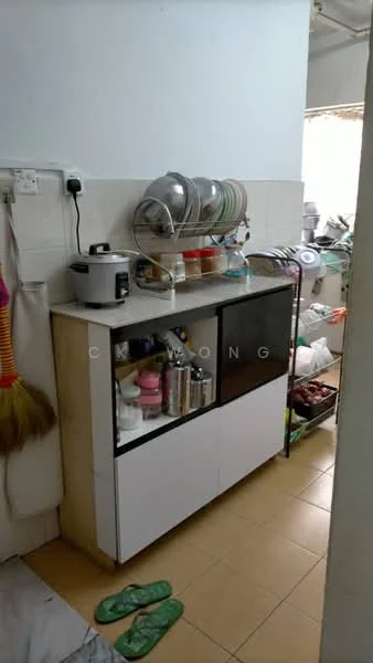 Kitchen features: white cabinetry with glass doors, countertop with storage underneath, stainless-steel rice cooker, various kitchen utensils and containers, ceramic plates and bowls, tile backsplash, yellow tiled flooring, window for natural light.