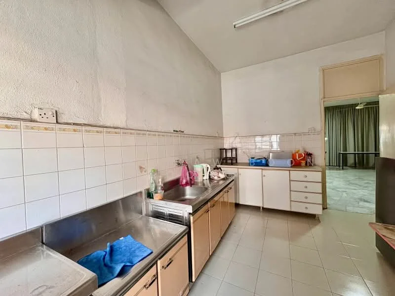 Kitchen features: double-bowl stainless-steel sink, chrome faucet, white tiled backsplash, light beige cabinetry, countertop with storage below, white ceramic tile flooring, high ceiling, overhead fluorescent lighting, window with curtain, open layout to adjacent room.