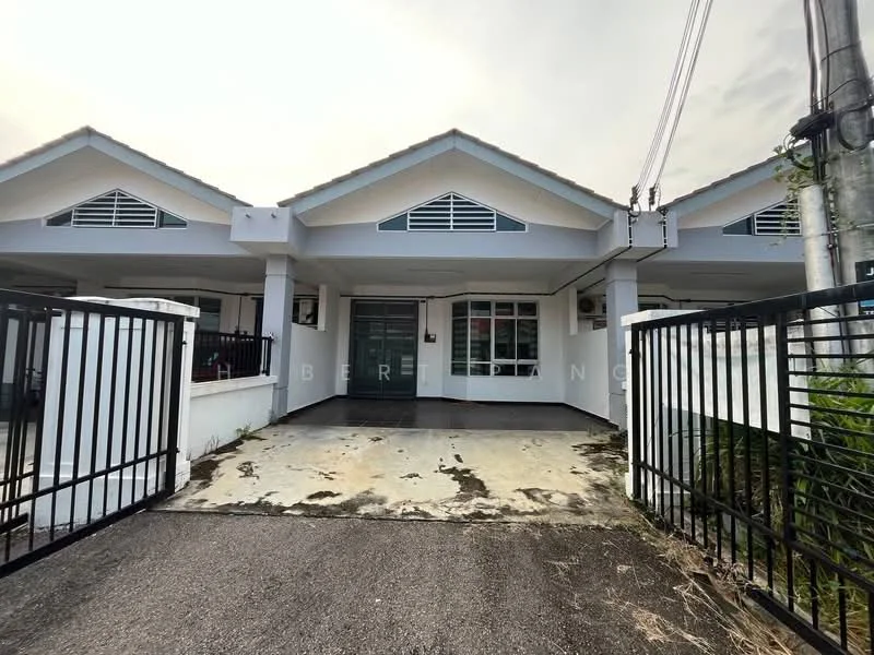 Exterior type: linked terrace house; features: white painted facade, gabled roof, front porch with concrete flooring, black metal gate, two visible windows on each side, front garden area, driveway leading to the house, exposed concrete wall, two-tone exterior paint, visible electrical wiring, surrounding greenery; style: modern.