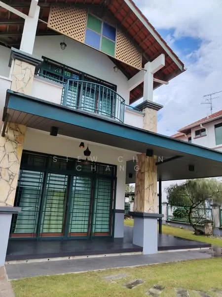 Exterior type: detached bungalow; features: stone cladding on facade, white painted facade, gabled roof, balcony with metal railing, large windows with green frames, covered porch area, manicured lawn, paved walkway, surrounded by greenery; style: modern.