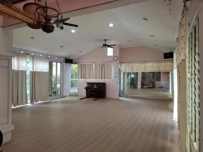 Room features: light wood laminate flooring, pink painted walls, high ceiling with recessed lighting, 2 ceiling fans, large mirrors on one wall, curtains on windows, wall clock, open space layout, natural light from windows, exposed wooden beams; style: modern; view: garden.