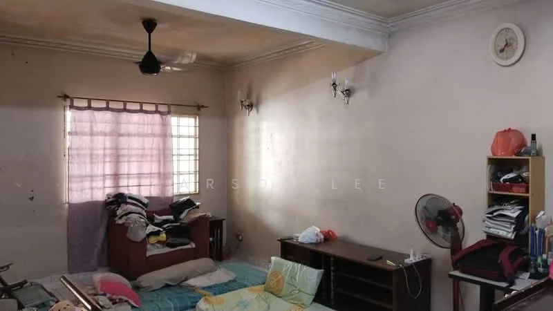 Living features: cream painted walls, ceiling fan, wooden furniture, sofa with cushions, coffee table, bookshelf, window with sheer curtains, wall clock, decorative wall sconces, scattered bedding, flooring not clearly visible.