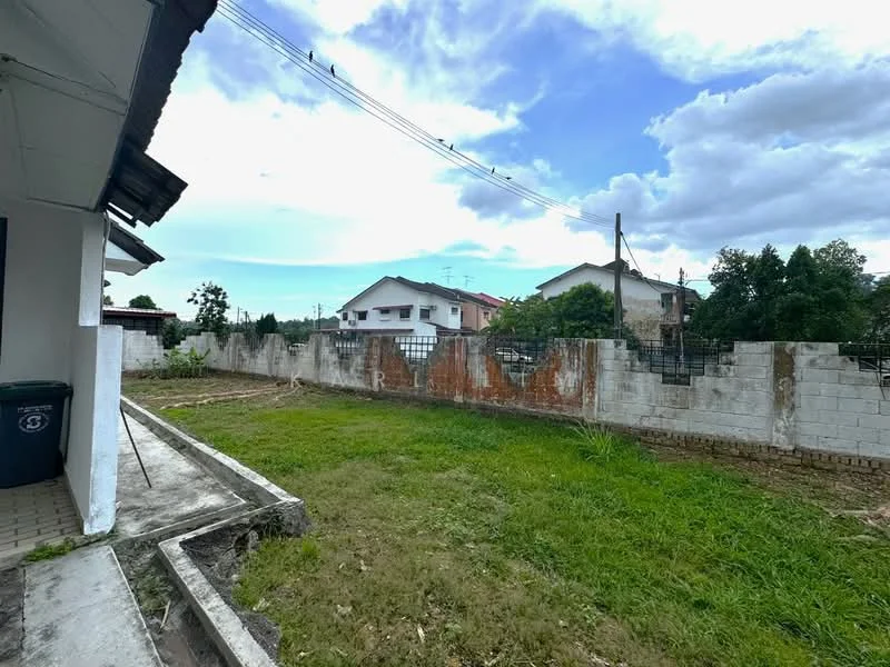 Exterior features: grass lawn, concrete pathway, exposed brick wall, fenced perimeter, residential buildings in background, overhead power lines, partially cloudy sky.