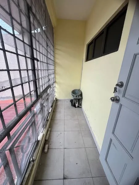 Room features: yellow painted walls, grey tiled flooring, large window with metal grille, single door, corner chair.