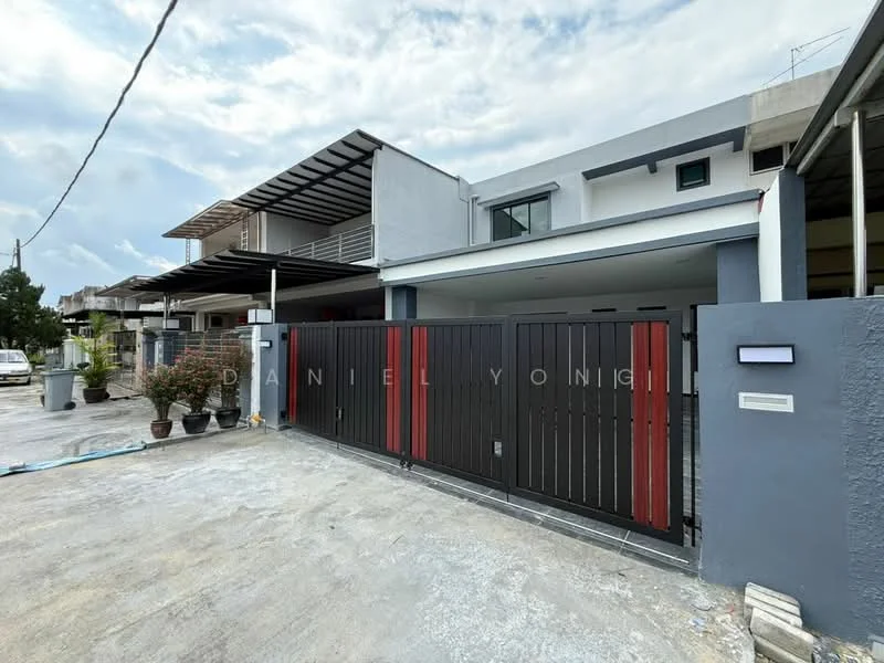 Exterior type: linked terrace house; features: black and red painted facade, two-storey structure, flat roof, manicured landscaping with potted plants, driveway with concrete surface, gate with horizontal slats, visible car porch, surrounded by residential area; style: modern.